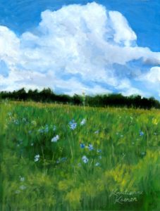 green field with small blue flowers