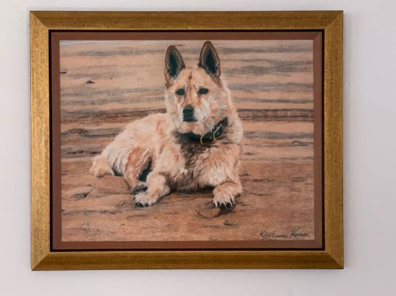 framed painting of dog on beach