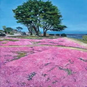 Tree with purple flowers in foreground and ocean in background