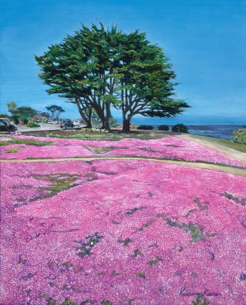 Tree with purple flowers in foreground and ocean in background